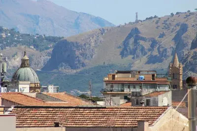 a group of buildings with mountains in the background at Dante Prime Collection Palermo in Palermo