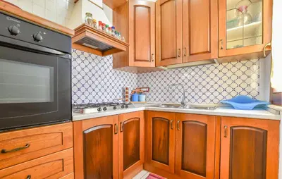 a kitchen with wooden cabinets and a black appliance at Villa Bruno in Castellammare del Golfo