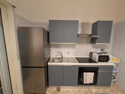 a small kitchen with a refrigerator and a sink at Settebello - Lolli in Palermo