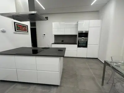 a kitchen with white cabinets and a black counter top at Granatelli Apartment in Palermo