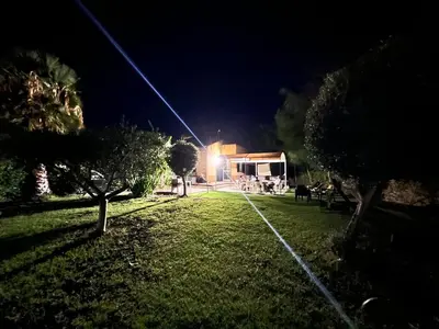 a yard with trees and a building at night at Villa Vulcano - Le Ville del Mediterraneo in Campofelice di Roccella