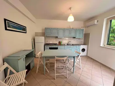 a kitchen with a table and chairs in a room at Villa Vulcano - Le Ville del Mediterraneo in Campofelice di Roccella