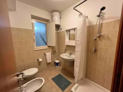 a bathroom with two toilets and a sink and a shower at Villa Vulcano - Le Ville del Mediterraneo in Campofelice di Roccella