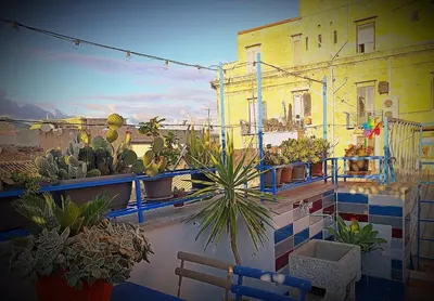a balcony with potted plants on a building at Casa Cutó near Central Station in Palermo