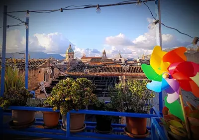 a view of a city from a balcony with potted plants at Casa Cutó near Central Station in Palermo