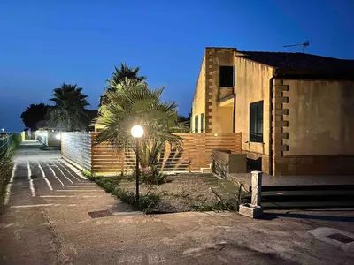 a street light next to a building with a palm tree at Villa Stromboli - Le Ville del Mediterraneo in Campofelice di Roccella