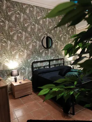 a bedroom with a bed and a table with a lamp at Guest House Scalia in Palermo
