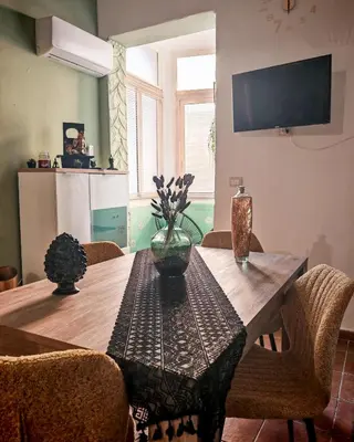 a dining room table with a vase of flowers on it at Guest House Scalia in Palermo