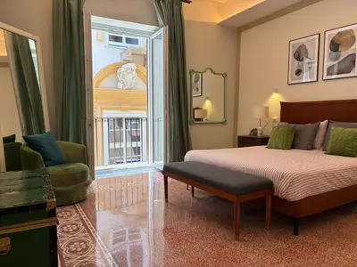 a bedroom with a bed and a chair and a window at Vista Cattedrale - City Center in Palermo