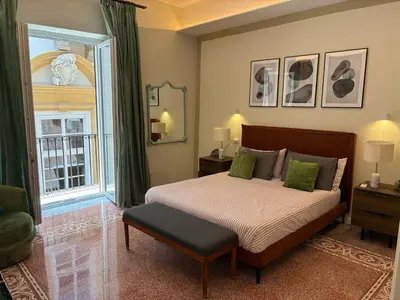 a bedroom with a bed and a large window at Vista Cattedrale - City Center in Palermo