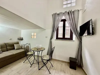 a living room with a couch and a table with chairs at Dimora Sant'Agostino 2 in Palermo