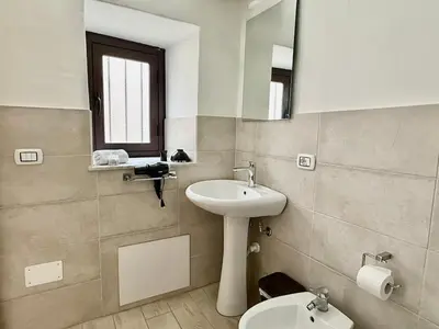 a bathroom with a sink and a toilet and a mirror at Dimora Sant'Agostino 2 in Palermo