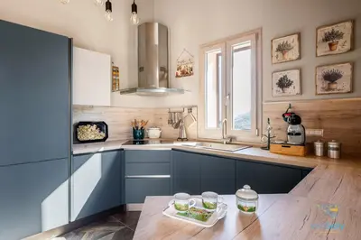 a kitchen with blue cabinets and a sink and a table at Verosicily Villa Pomelia in Termini Imerese