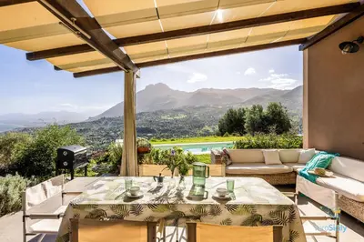 a table and chairs on a patio with a view at Verosicily Villa Pomelia in Termini Imerese