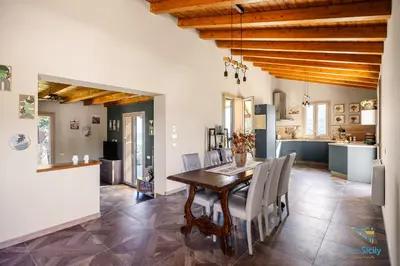 a kitchen and dining room with a wooden table and chairs at Verosicily Villa Pomelia in Termini Imerese
