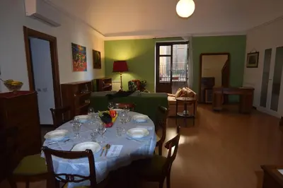 a dining room with a table with plates and wine glasses at Carlita's Home in centro storico a Palermo in Palermo