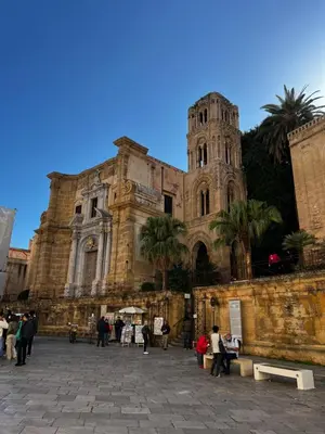 a building with two towers and a palm tree at Casa 3 Cupole, Historic Soul and Contemporary Design in Palermo