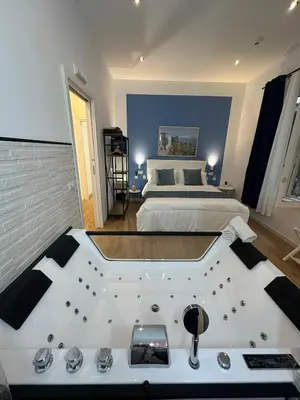a bedroom with a large tub in front of a bed at Isole Siciliane Appartamento in Palermo
