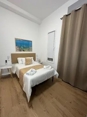 a white room with two beds and a window at Isole Siciliane Appartamento in Palermo