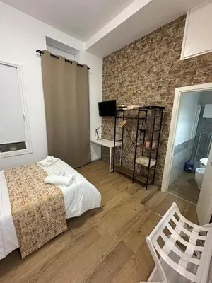a bedroom with a bed and a brick wall at Isole Siciliane Appartamento in Palermo