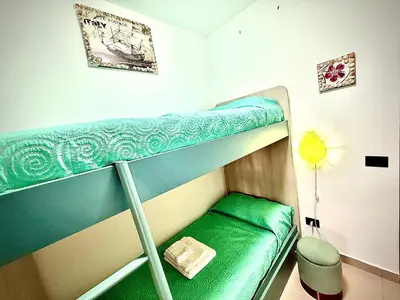 a green bunk bed in a small room at Pine Beach House - Villaggio Turistico con Piscina e Animazione in Campofelice di Roccella