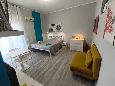 a bedroom with a bed and a table and a chair at Central Apartment Cavour in Palermo