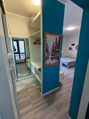 a room with a blue wall with a bed and a mirror at Central Apartment Cavour in Palermo