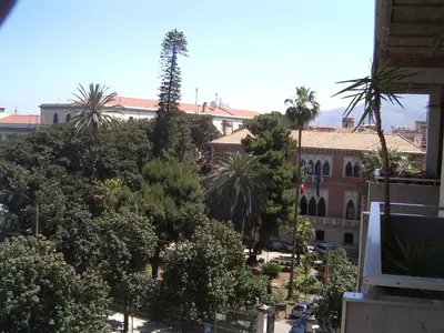 a view of a city with trees and a building at Central Apartment Cavour in Palermo