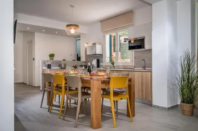 a kitchen with a wooden table and yellow chairs at Villa Coraline in Castellammare del Golfo