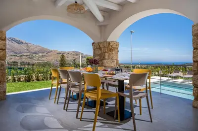 an outdoor dining room with a table and chairs at Villa Coraline in Castellammare del Golfo