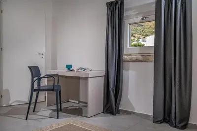 a desk and chair in a room with a window at Villa Coraline in Castellammare del Golfo