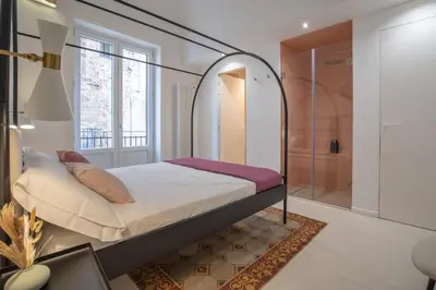 a white bathroom with a toilet and a window at Dimora Dodici, Heritage and Contemporary Design in Palermo