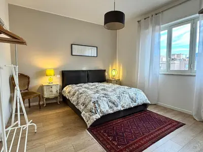 a bedroom with a bed and a chair and a window at Casa Parlatore in Palermo