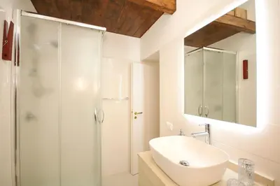 a white bathroom with a sink and a shower at La Dimora di Guglielmo Tourist Rental in Palermo