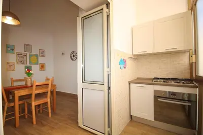 a kitchen with a refrigerator and a table at La Dimora di Guglielmo Tourist Rental in Palermo