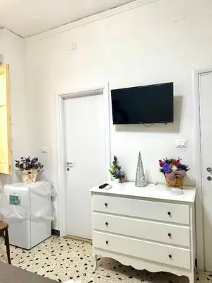 a white dresser with a flat screen tv on a wall at Da Nonna Marié in Palermo