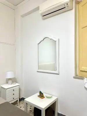 a white room with a mirror and a table at Da Nonna Marié in Palermo