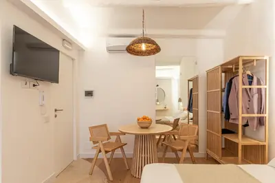 a living room with a table and chairs and a tv at Meraki Home - Alle Spalle del Teatro Massimo in Palermo