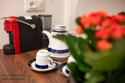 a table with cups and a vase with flowers on it at Accordi al Politeama in Palermo