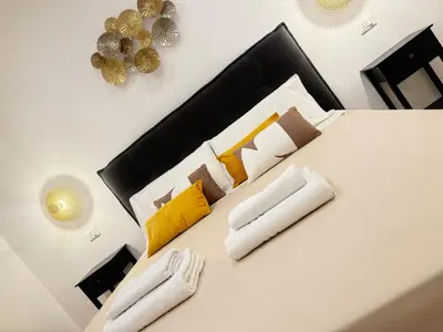 a bedroom with a white bed with two white towels at Ughetti Apartment in Palermo