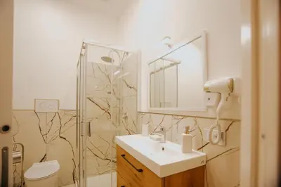 a bathroom with a sink and a toilet and a mirror at Cama Luxury Rooms in Palermo