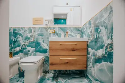 a bathroom with a white toilet and a sink at Cama Luxury Rooms in Palermo
