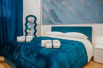 a bedroom with a blue bed with towels on it at Cama Luxury Rooms in Palermo