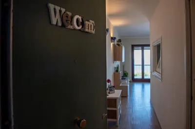 a room with a green door and a hallway at CasaMare Addaura - Your Romantic Seafront Hideaway in Palermo