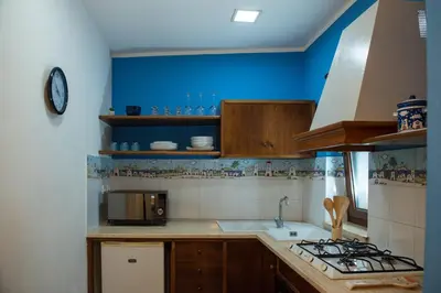 a kitchen with a sink and a stove top oven at CasaMare Addaura - Your Romantic Seafront Hideaway in Palermo