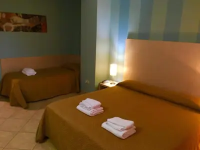 a hotel room with two beds with towels on them at Hotel Villa Mare in Altavilla Milicia