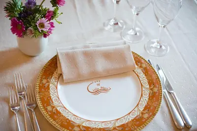 a plate with a napkin on top of a table at Hotel Villa Mare in Altavilla Milicia