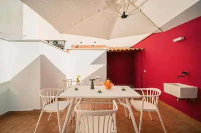 a room with a table and chairs and an umbrella at LeSicilien - Fior di Sicilia - Apartment with Terrace in Palermo