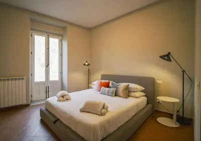 a bedroom with a bed with pillows and a lamp at LeSicilien - Fior di Sicilia - Apartment with Terrace in Palermo