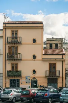 a building with cars parked in front of it at LeSicilien - Fior di Sicilia - Apartment with Terrace in Palermo